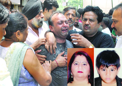 Pawan Nagia being consoled by relatives after the murder of his wife Anuradha and son Cherish (inset) in New Delhi.
