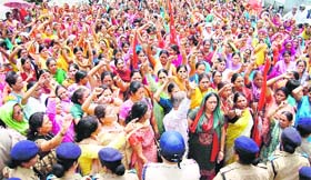 Anganwadi workers hold a protest in front of the state secretariat in Dehradun on Friday.