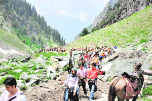 Pilgrims trudge on an arduous track near Pissu Top en route the Amarnath cave shrine.
