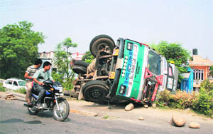 A truck overturned when its driver lost control over it near Indra Nagar on the Jammu-RS Road on Friday. 
