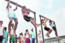 Candidates doing chin-ups during the recruitment rally in Ludhiana on Friday. 