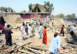 Residents stand in the rubble of the aftermath of a suicide blast in Pakistans northwestern Mohmand region on Friday