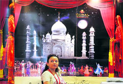 A travel agency representative walks past a promotional hoarding during the first day of the three-day India International Travel Mart 2010 in Bangalore on Saturday. About 250 participants from 15 countries are expected to participate in the event