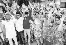 Residents of Sunder Nagar, Rajpura, protest against the frequent power cuts imposed by the Powercom on Saturday.
