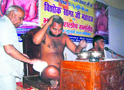 Digambar Jain saint Sri Sri 108 Vishok Maharaj plucks his hair during the Kesh Loach ceremony in Mussoorie on Saturday.