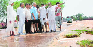 Ambala city MLA Venod Sharma inspects a partially washed away road in Chhapra village, Ambala, on Saturday.
