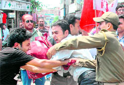 Members of the All-India Students Federation scuffle with the police during a protest against the Bhopal gas tragedy issue at City Chowk in Jammu 