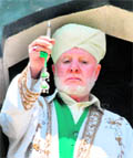 Cleric Ghulam Hassan Banday shows a glass tube carrying what is believed to be the relic of Prophet Mohammad to the congregation