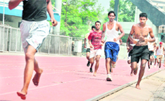Candidates run bare foot in the physical fitness test during a recruitment drive by the Army in Ludhiana