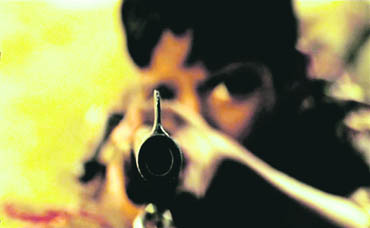 Nine-year-old Manka aims at Lallan, Thakurs brother-in-law, with a rifle