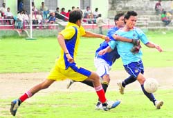 A goalkeeper tries to prevent a player from scoring a goal in a match of the Nemi Dass Memorial Football League played at the Pavillion Ground in Dehradun on Sunday.