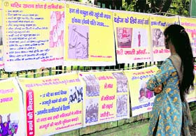 A girl watches a poster exhibition on World Population Day in Dehradun on Sunday.