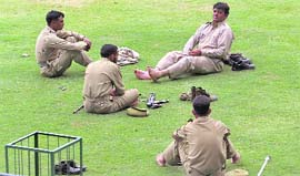 Cops rest after curfew is lifted in Srinagar on Sunday.