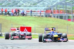 Red Bulls Australian driver Mark Webber drives ahead of McLaren Mercedes British driver Lewis Hamilton at the Silverstone circuit on Sunday during the Formula One British Grand Prix.