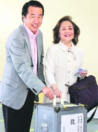 Japan's Prime Minister Naoto Kan and his wife Nobuko cast their votes for the upper house election at a polling station in Tokyo