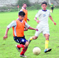 Players vie for the ball at the Lala Nemi Dass District Football League on Monday