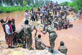 Armymen try to plug a breach in the SYL canal near Jyotisar