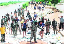 Armymen try to plug a breach in the Hansi-Butana canal in Kaithal