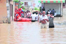 Security personnel take marooned people in a boat in Kurukshetra district
