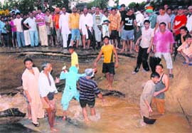Residents help commuters as a road caved in near Mohra village