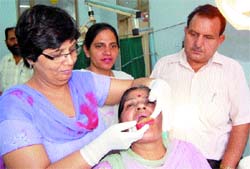 Dr Ashok Sharma, checks a woman at the free dental camp in Jallianwala Bagh Civil Hospital in Amritsar on Tuesday