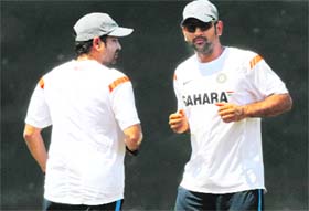 Sachin Tendulkar (L) and captain Mahendra Singh Dhoni warm up during a practice session in Colombo