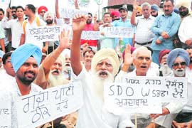 Residents protest against impure drinking water supplied by the Municipal Council, at Tahli Wala Chowk in Rajpura on Tuesday.