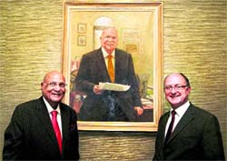 Lord Swraj Paul (left) stands besides his portrait, painted by renowned British artist Michael Noakes, after it was unveiled by him at the University of Westminster in central London on Monday