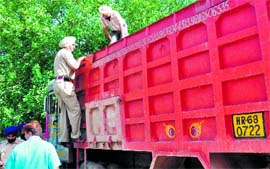 A policeman inspects the tipper impounded by State Transport Authority officials for overloading at the Sector 31 police station in Chandigarh on Wednesday