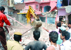 Rescue workers clear the debris after a three-storey building collapsed at Brahmapuri in New Delhi 