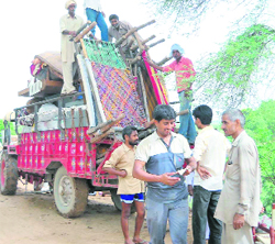 Villagers in Firozabad load their belongings on a tractor-trailer to shift to safer destinations after flood waters entered their village 