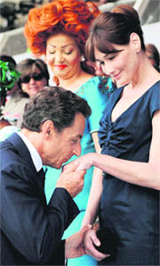 Watched by Cameroon's first lady Chantal Biya, French President Nicolas Sarkozy kisses the hand of his wife Carla Bruni-Sarkozy, during the annual Bastille Day military parade in Paris on Wednesday.