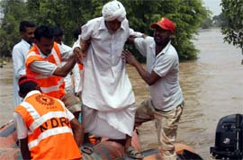 Men of the National Disaster Response Force rescue a village elder marooned due to flood waters in Sadhuwala village of Mansa on Thursday