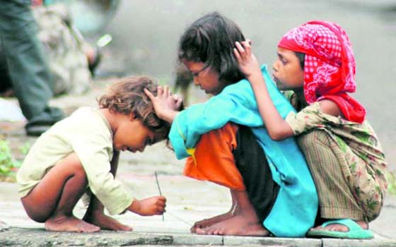 Poor children busy looking for lice on each others heads in Dehradun on Thursday.