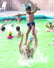 With no relief from heat and humid conditions, children cool themselves off in a swimming pool in Amritsar.