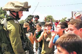 Palestinian boys taunt an Israeli officer during a protest in the West Bank town of Nabi saleh, near Ramallah, on Friday.