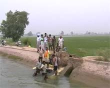 Workers try to plug the breach in Laxman distributary in Mamdot area of Ferozepur district on Saturday. 