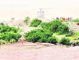 An Army helicopter lands on an island in the Tawi river near Hari Ki Pouri temple to rescue trapped pilgrims in Jammu on Saturday.