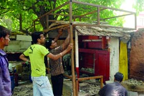Workers construct an NDMC shop near the Commonwealth Games office at Jantar Mantar in New Delhi on Sunday.