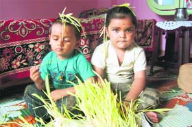 Kids with green leaves on their heads participate in the Harela puja ceremony in Pitthoragarh