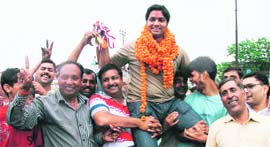 Arun Singh being lifted by locals on his arrival after winning gold at the Singapore Open Shooting Championship in Dehradun on Monday.