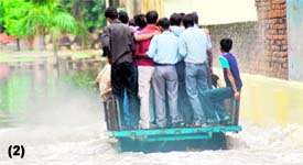 Boys ride through the waterlogged streets