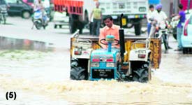 A tractor-trolley wades through rainwater in Haridwar
