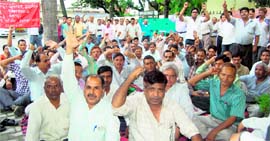 Workers of Jal Nigam hold a dharna in Dehradun on Monday.