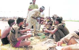 Members of an NGO serve lunch to labourers plugging a breach in the Ghaggar near Firozabad in Sirsa