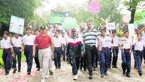 Students and Army personnel hold a procession as part of the Van Mahotsav celebrations at Udhampur military station on Monday.