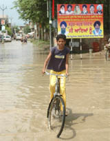 A boy rides his bicycle through accumulated rainwater in Bathinda on Wednesday. 