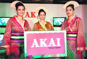 Models pose with Akai television in New Delhi on Wednesday. Akai announced its re-entry into the Indian market with new range of ultra slim LED and LCD televisions.