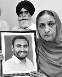 Bhupinder Kaur shows the picture of her son Gurdeep Singh during a press conference at Phase IV in Mohali on Wednesday