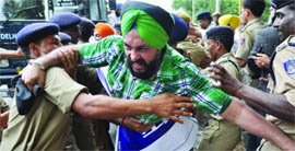 Activists of the SAD (B) shout slogans as the Delhi police stops them during a protest against DSGMC president Paramjit Singh Sarna in New Delhi on Thursday.